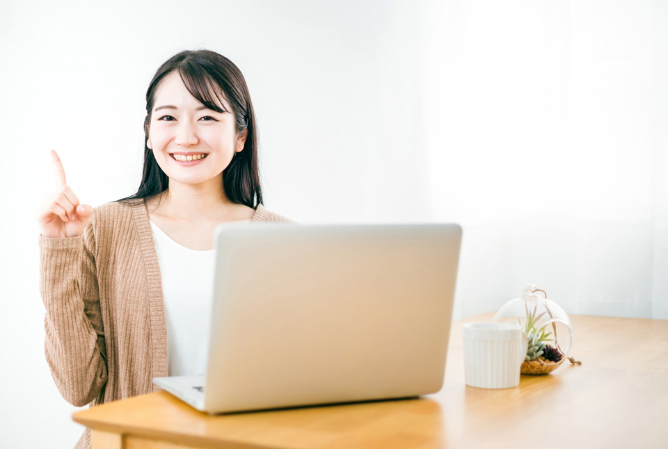 パソコンの前で指を差す女性