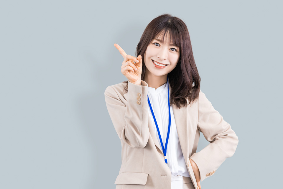 指を指す笑顔の女性