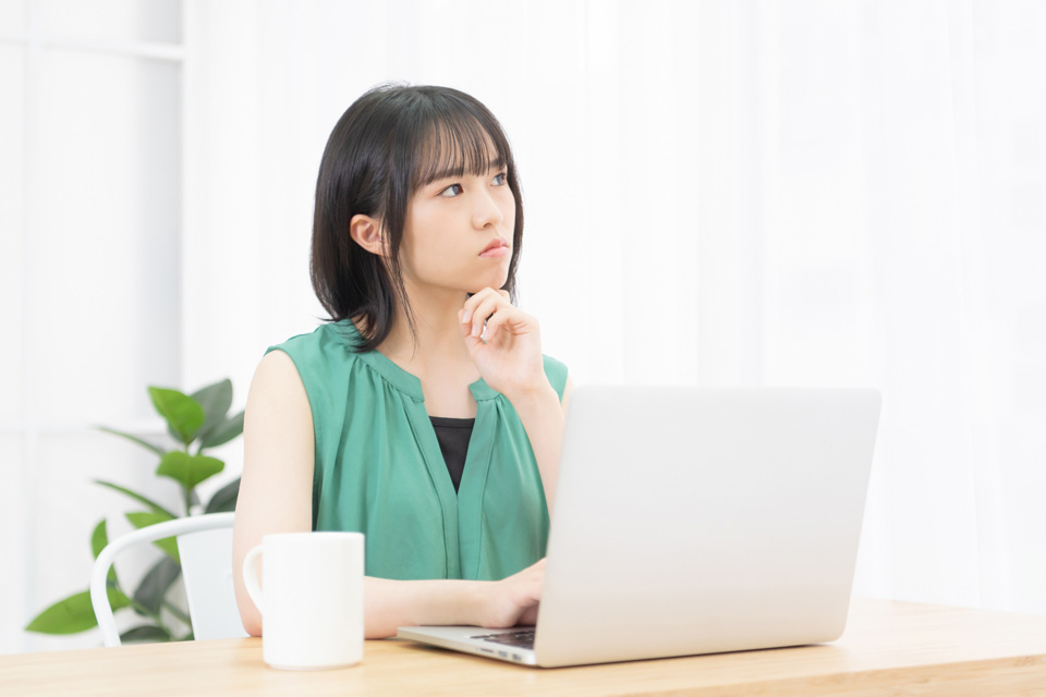 パソコンの前で考える女性