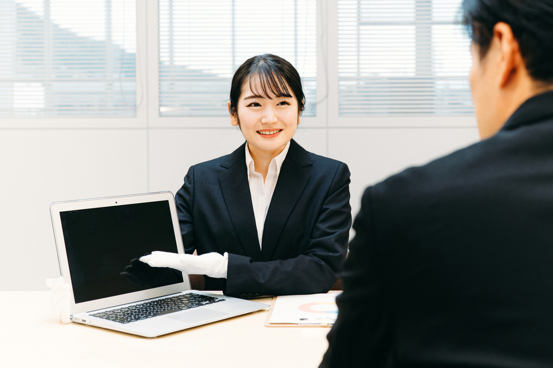 パソコンを査定する女性