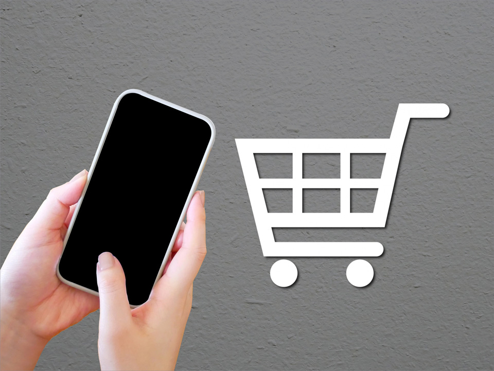 スマホを持つ手と買い物カゴ