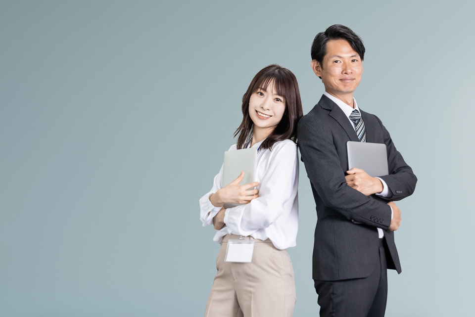 ノートパソコンを抱える男性と女性