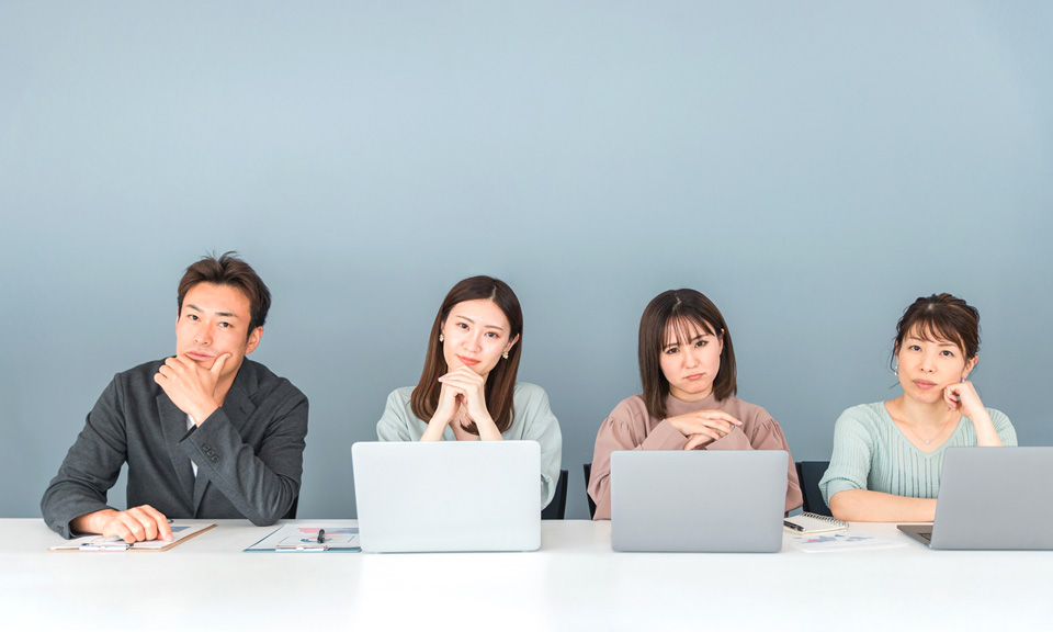 オフィスでノートパソコンを前にこちらを見る男性と女性