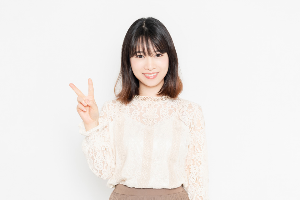 「2つ」と2本の指を立てる女性
