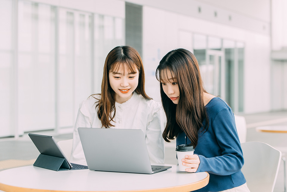 パソコンを見る二人の女性