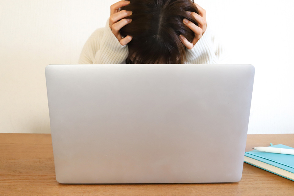 パソコンの前で頭を抱える人