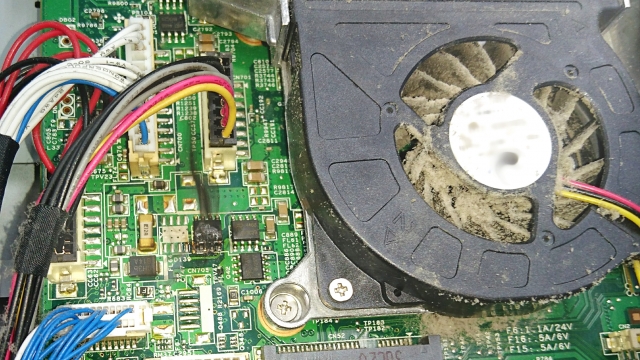 埃で汚れたパソコンの内部。ファンとマザーボード。